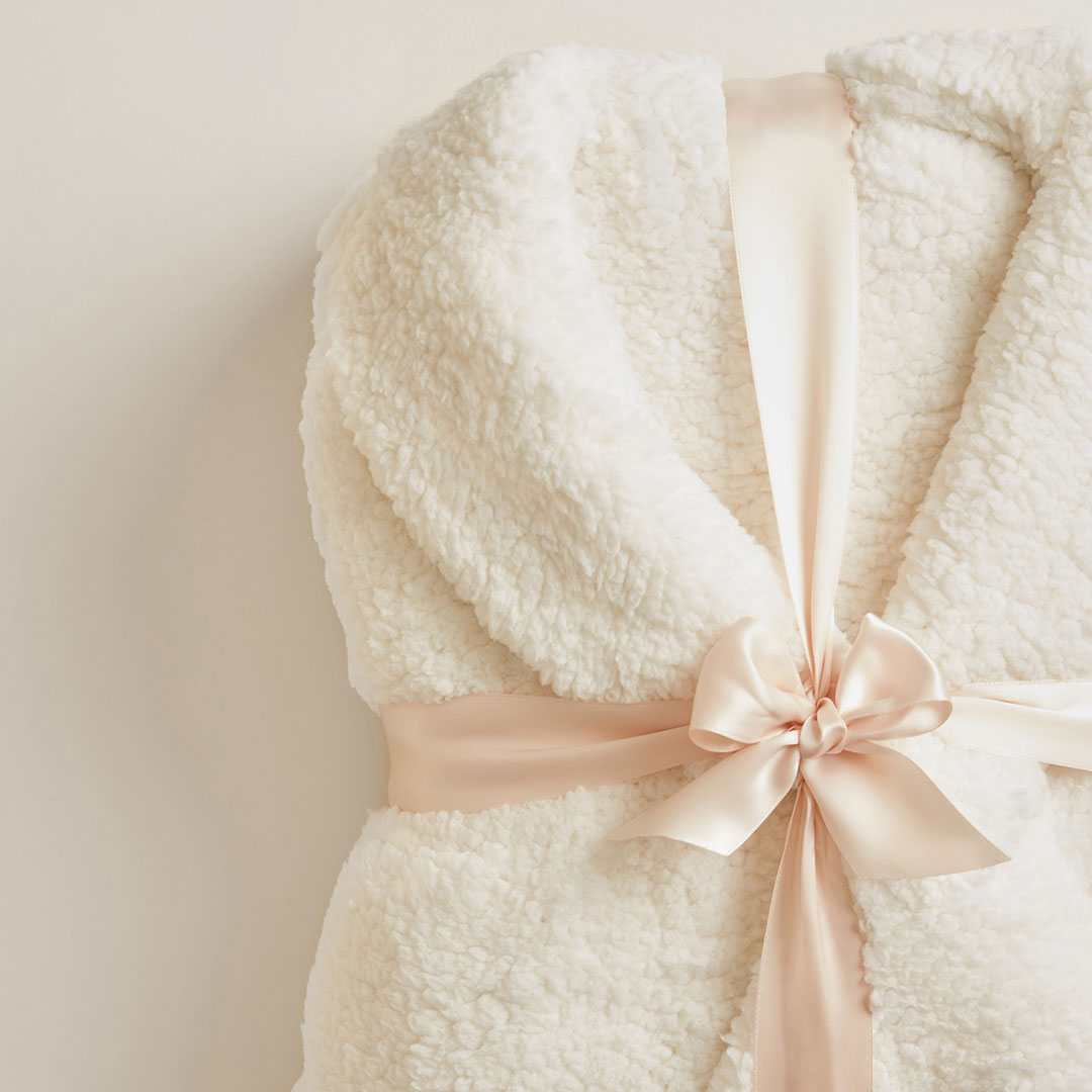 Soft goods robe wrapped in a bow styled and shot by accessories still life photographer Kate Benson.