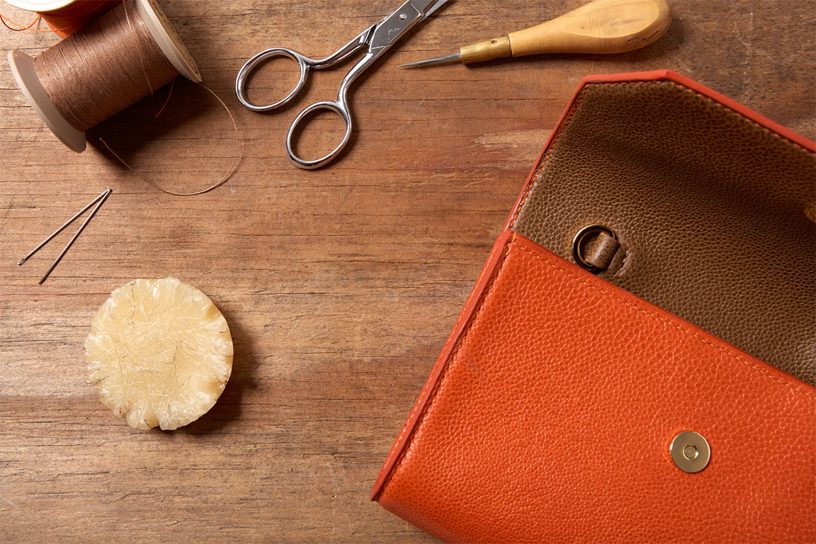 Soft and hard goods accessories photographer Kate Benson photographed creative flatlay of leather purse.