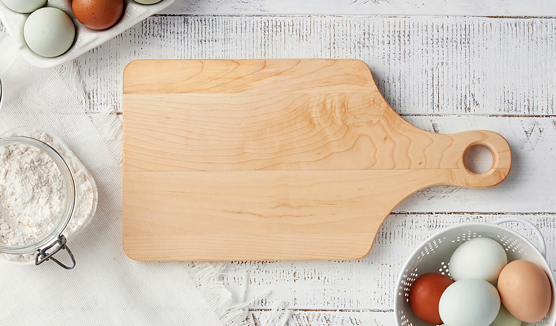 Cutting board with eggs and flour against shiplap photographed by food and beverage photographer Kate Benson.