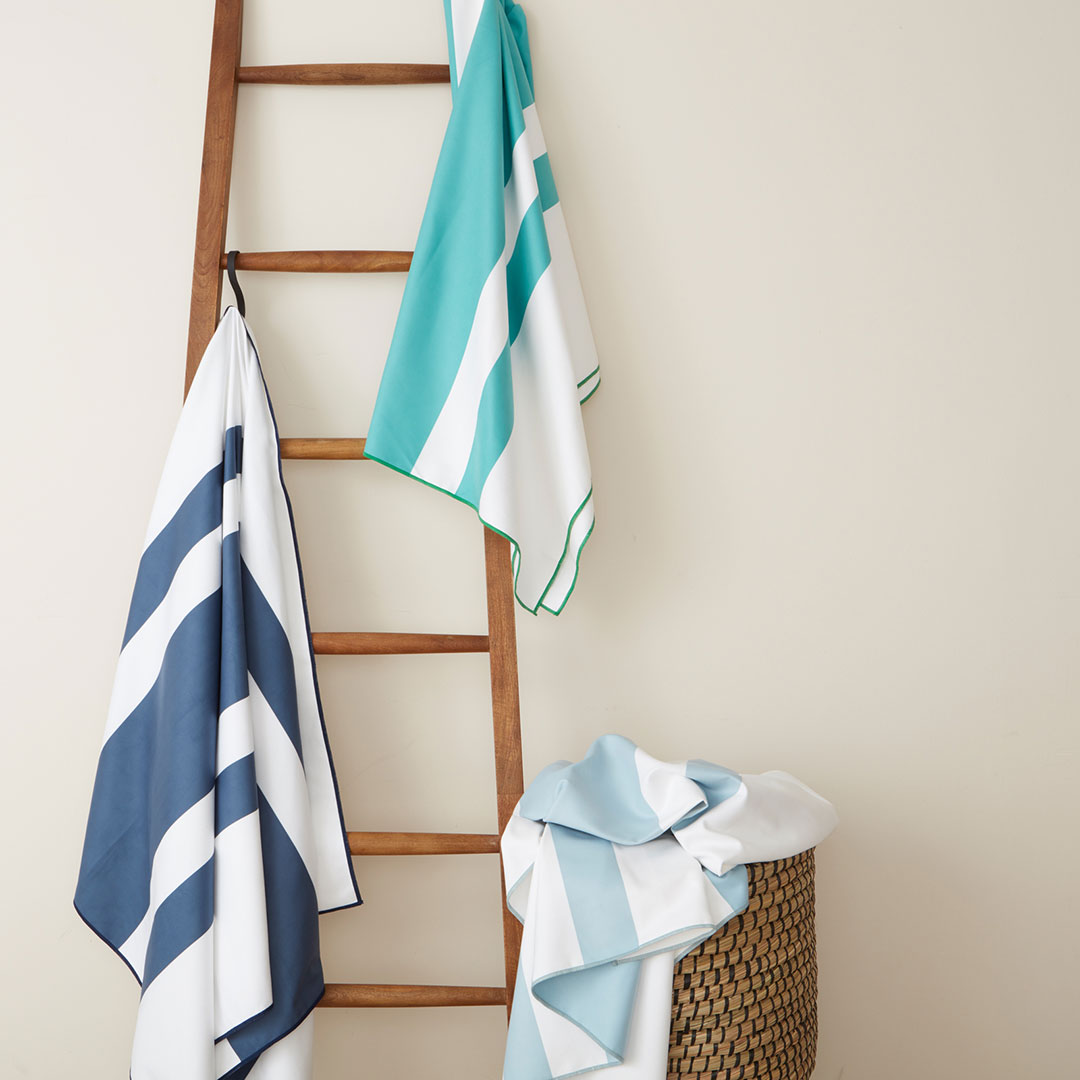 Towels hanging on ladder and laying on basket photographed by still life photographer Kate Benson.