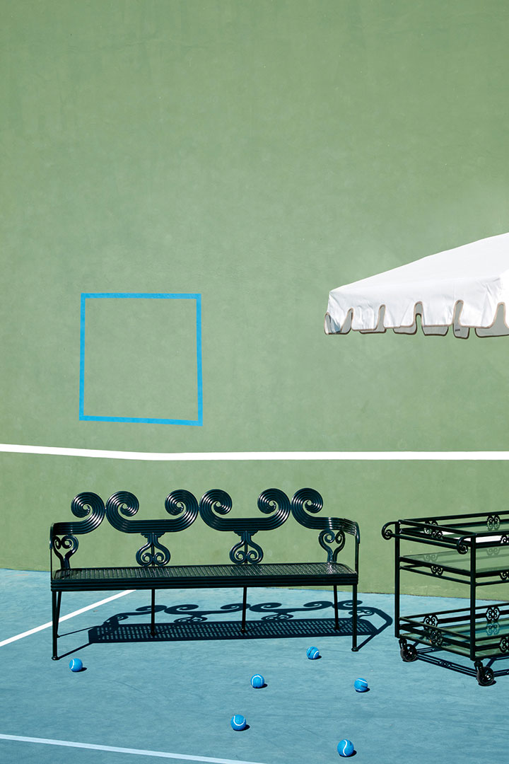 Metal bench and bar table on tennis court photographed by furniture photographer Kate Benson.