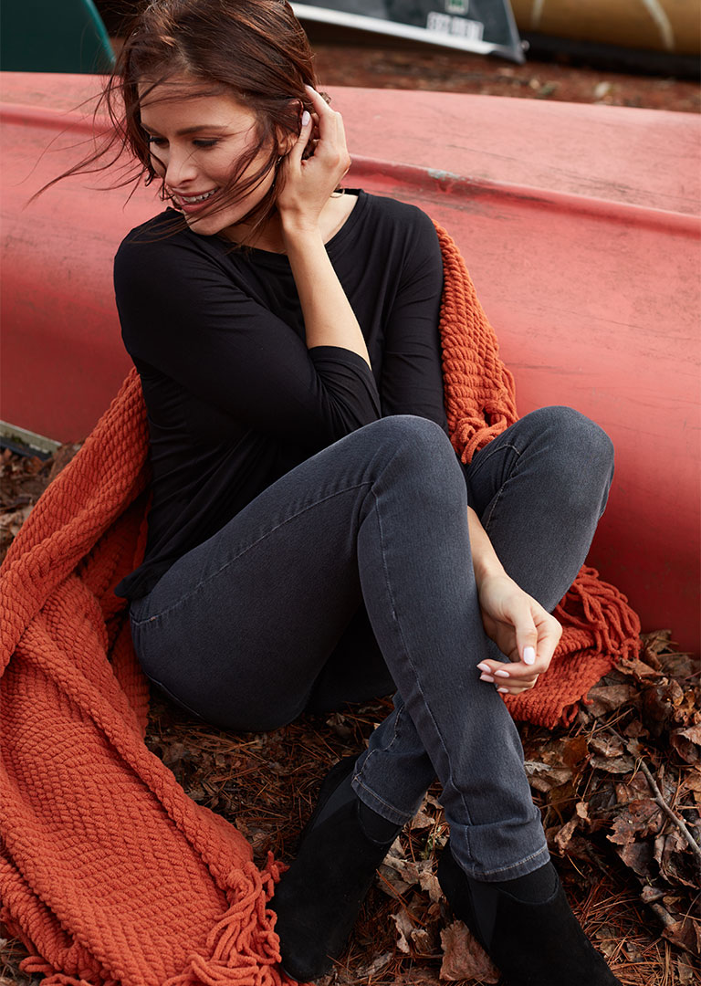 Model sitting in fall foliage photographed by professional fashion photographer Kate Benson.