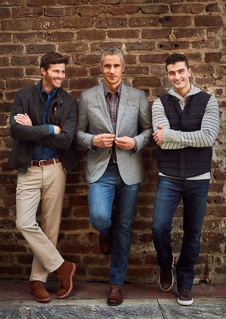 Professional male models leaning on brick wall photographed by advertising photographer Kate Benson.