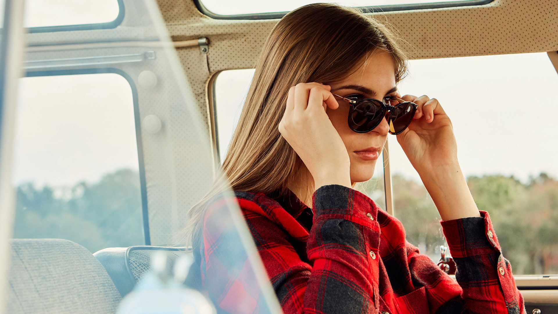 Model in car with sunglasses and plaid shirt photographed by advertising photographer Kate Benson.