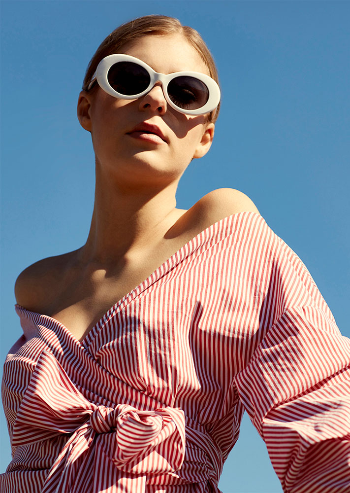 Model wearing red and white striped top and sunglasses photographed by professional fashion photographer Kate Benson.