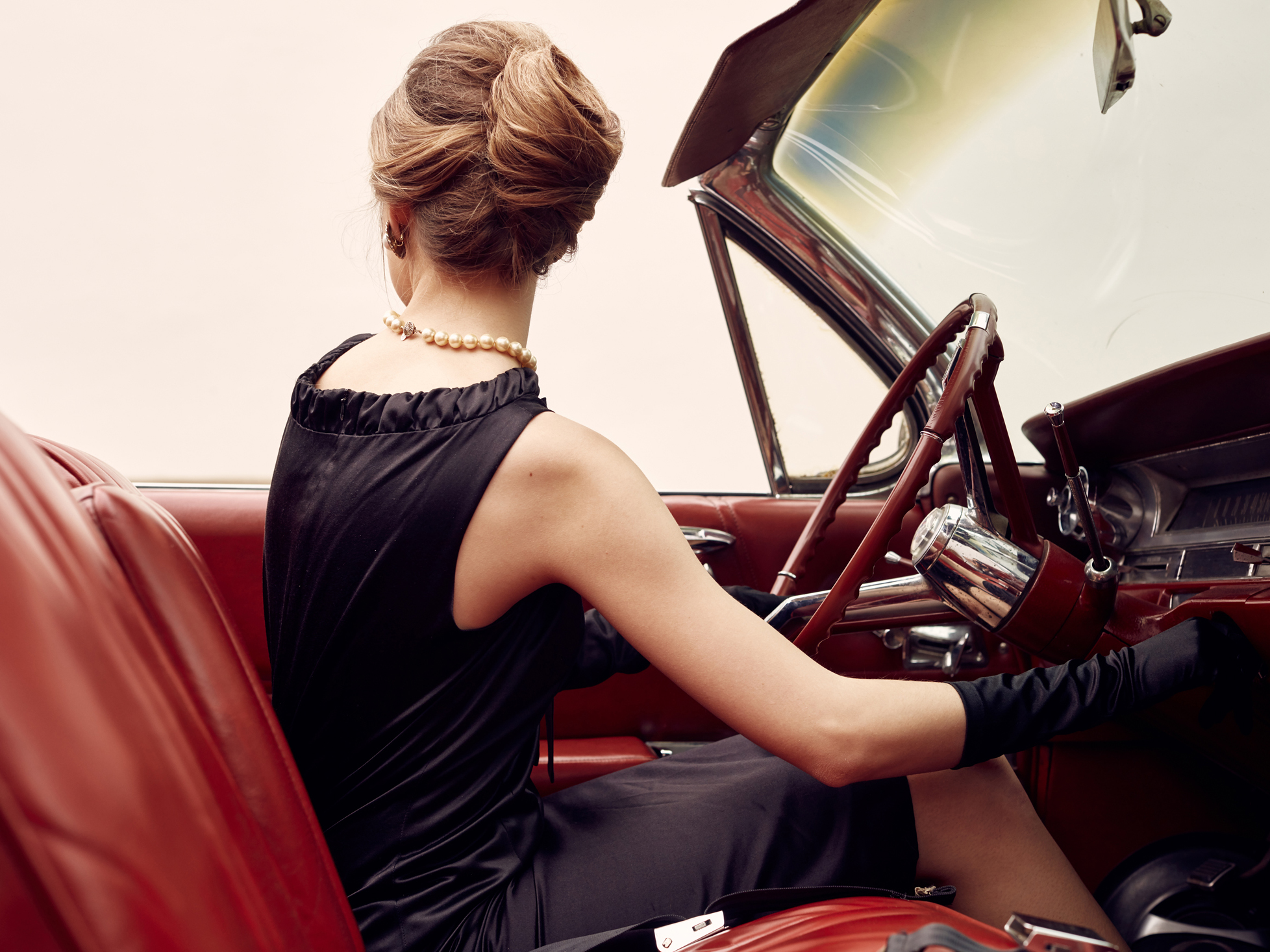 Fashion model sitting in car photographed by advertising photographer Kate Benson.