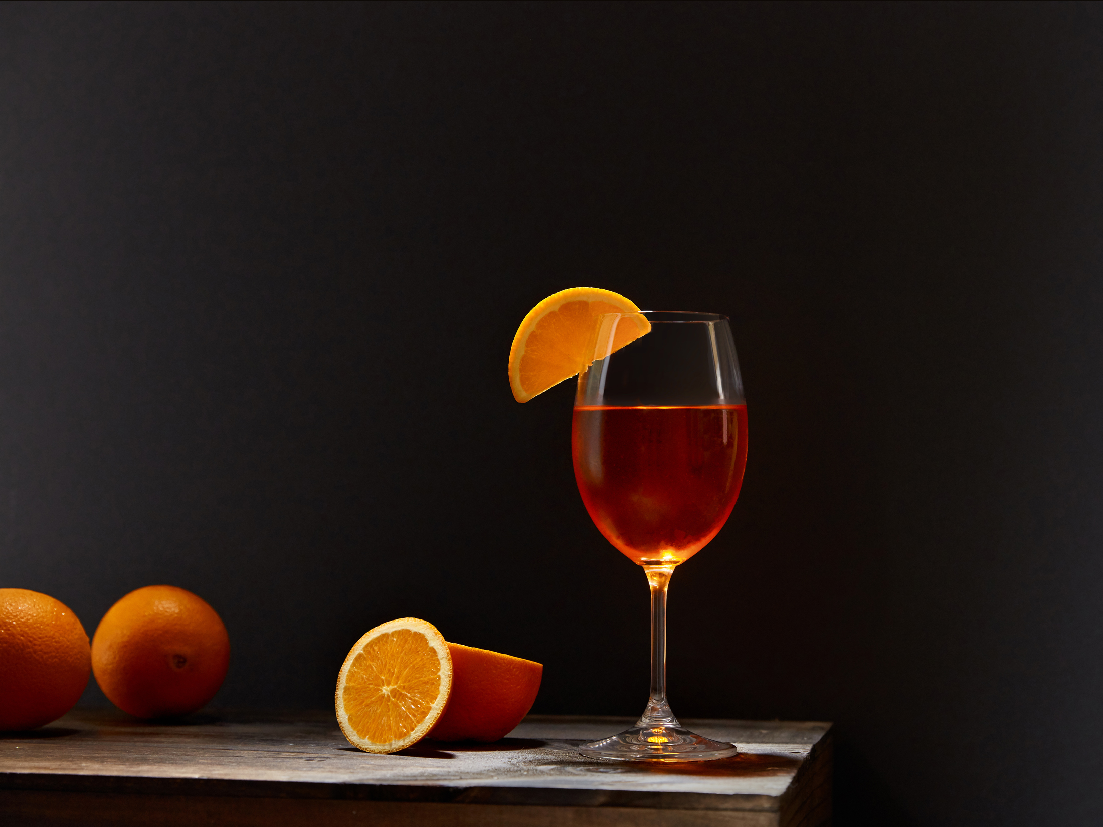 Oranges and drink on wooden table photographed by professional food and beverage photographer Kate Benson.